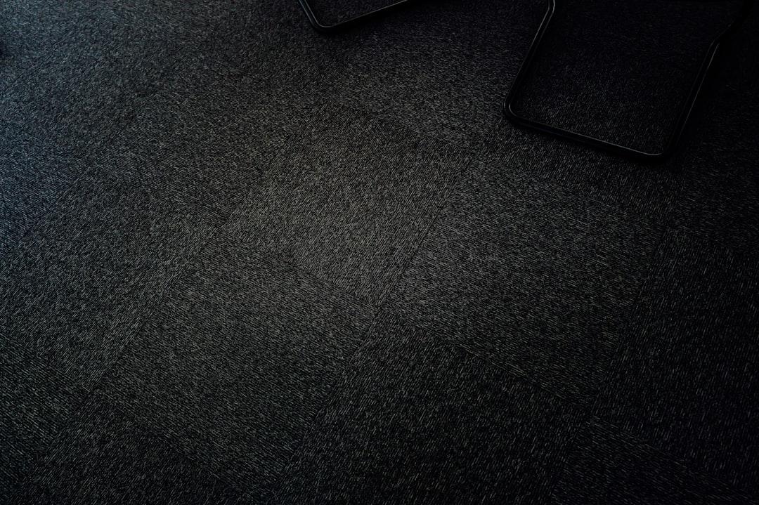 Dark, grainy texture with a glimpse of objects.