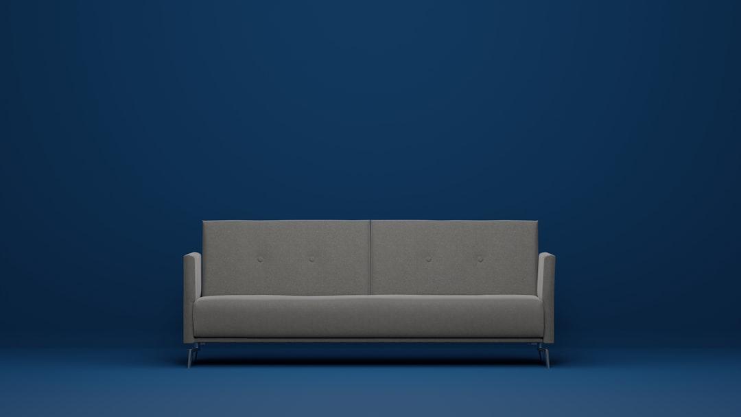 a gray couch against a blue wall