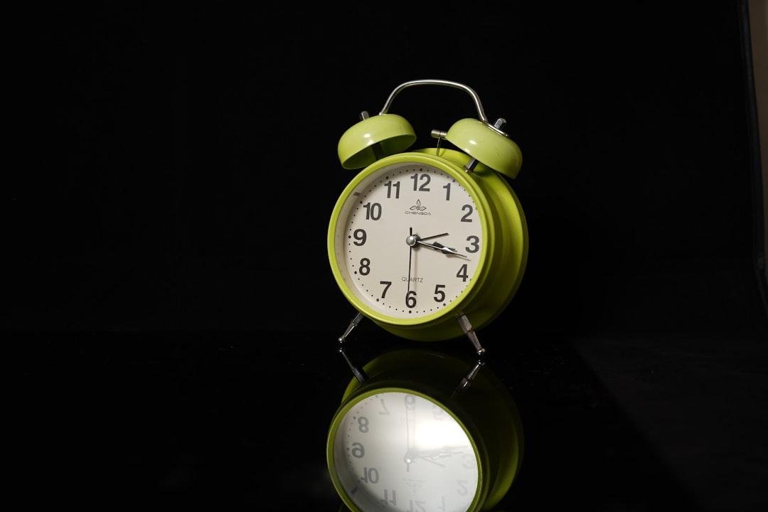 a green alarm clock sitting on top of a table