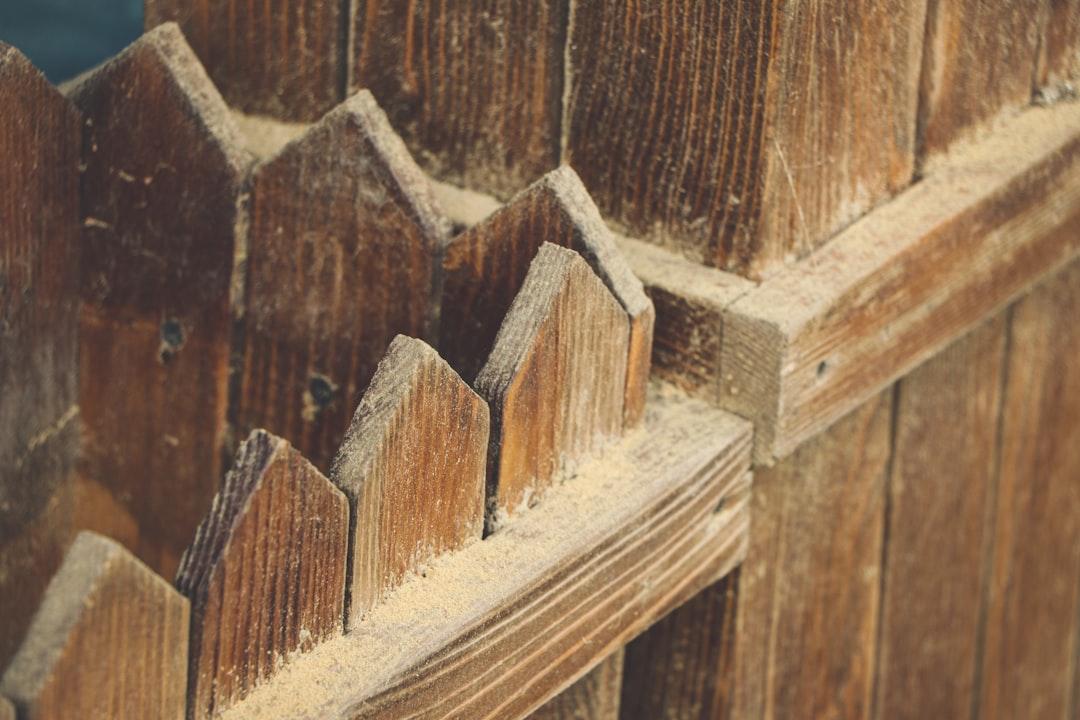 a close up of a wooden fence with snow on it