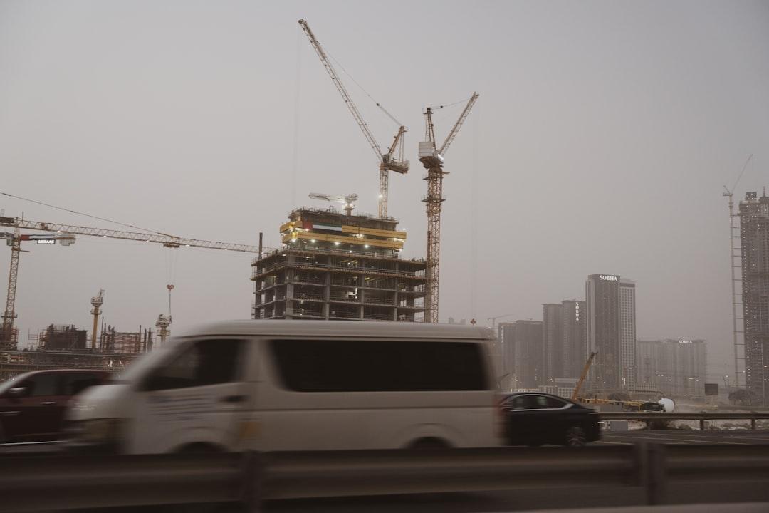 Construction cranes tower over a city skyline.