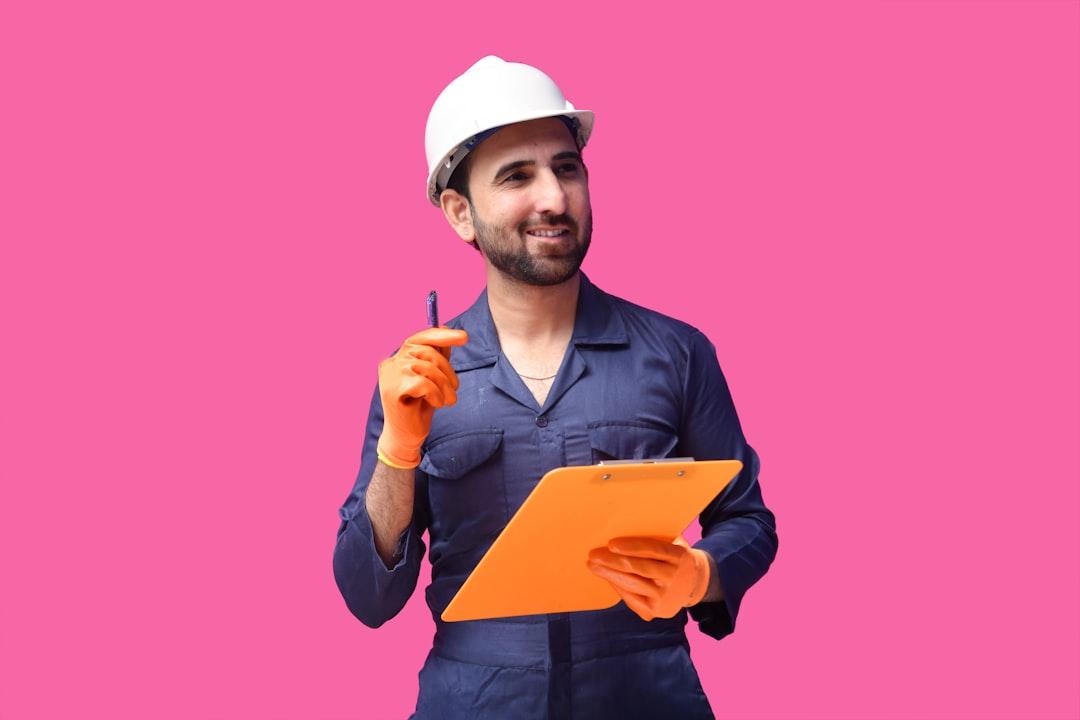 a person wearing a hard hat and holding a pen