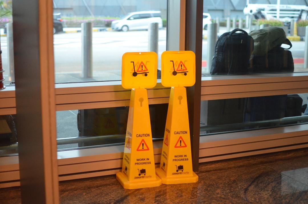A couple of yellow caution signs sitting in front of a window