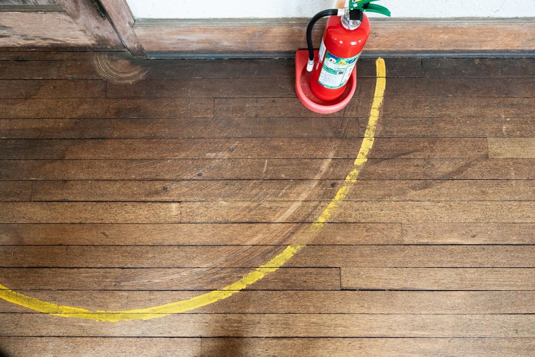 A red fire hydrant sitting on top of a wooden floor