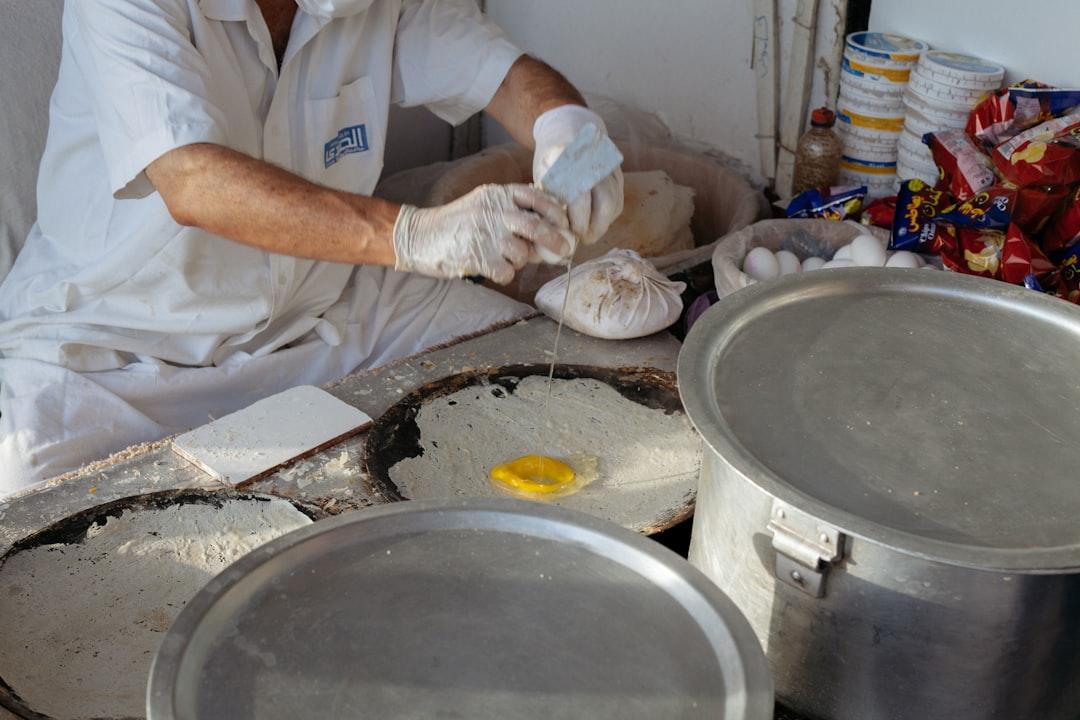 a man in a white shirt and some metal pans