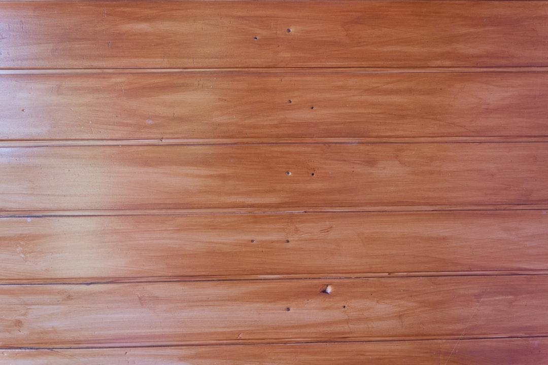a cat laying on a wooden floor next to a wall