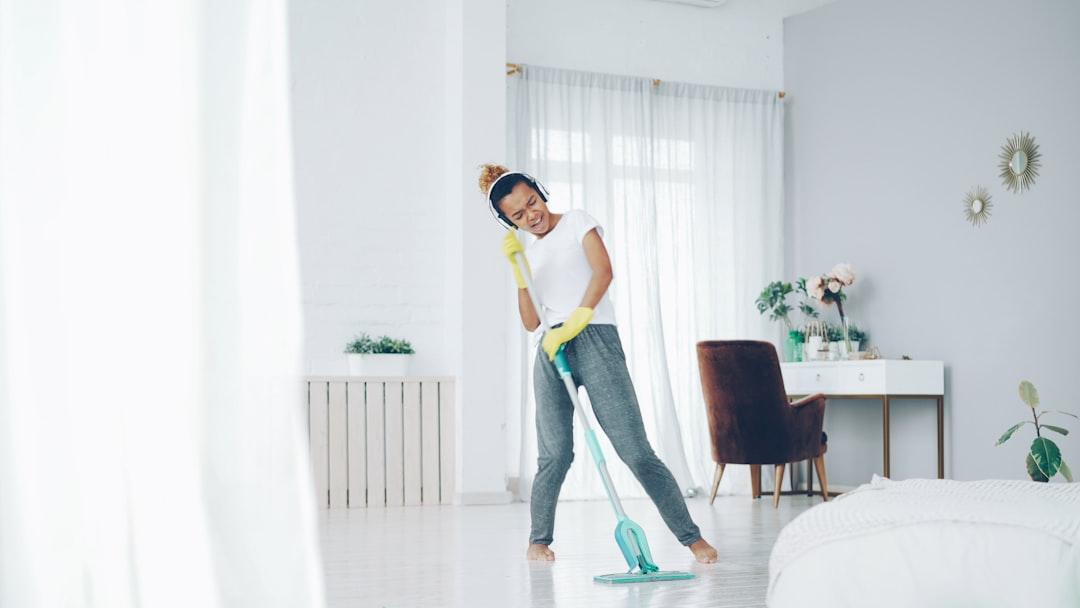 Woman happily mopping a bright, modern living room.